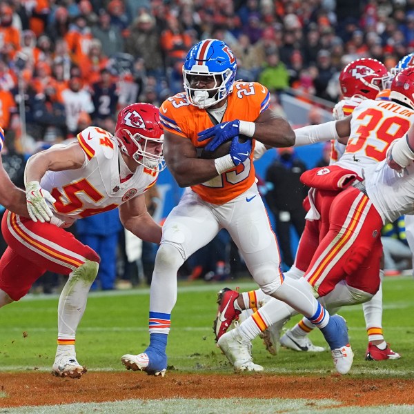 Denver Broncos running back Audric Estime (23) scores past Kansas City Chiefs linebacker Leo Chenal (54) during the second half of an NFL football game Sunday, Jan. 5, 2025, in Denver. (AP Photo/David Zalubowski)