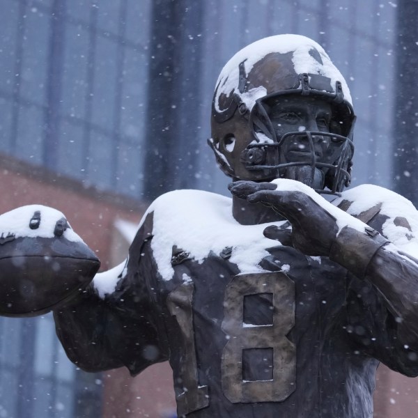 A statue of Peyton Manning by Ryan Feeney is dusted with snow outside Lucas Oil Stadium after an NFL football game between the Indianapolis Colts and the Jacksonville Jaguars, Sunday, Jan. 5, 2025, in Indianapolis. (AP Photo/Michael Conroy)