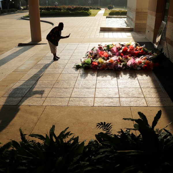 FILE - A woman stops to photograph a memorial for George Floyd at The Fountain of Praise church in Houston, June 9, 2020, in Houston. (AP Photo/Eric Gay, File)