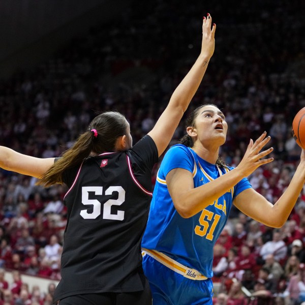 UCLA center Lauren Betts (51) shoots over Indiana forward Lilly Meister (52) in the second half of an NCAA college basketball game in Bloomington, Ind., Saturday, Jan. 4, 2025. (AP Photo/Michael Conroy)