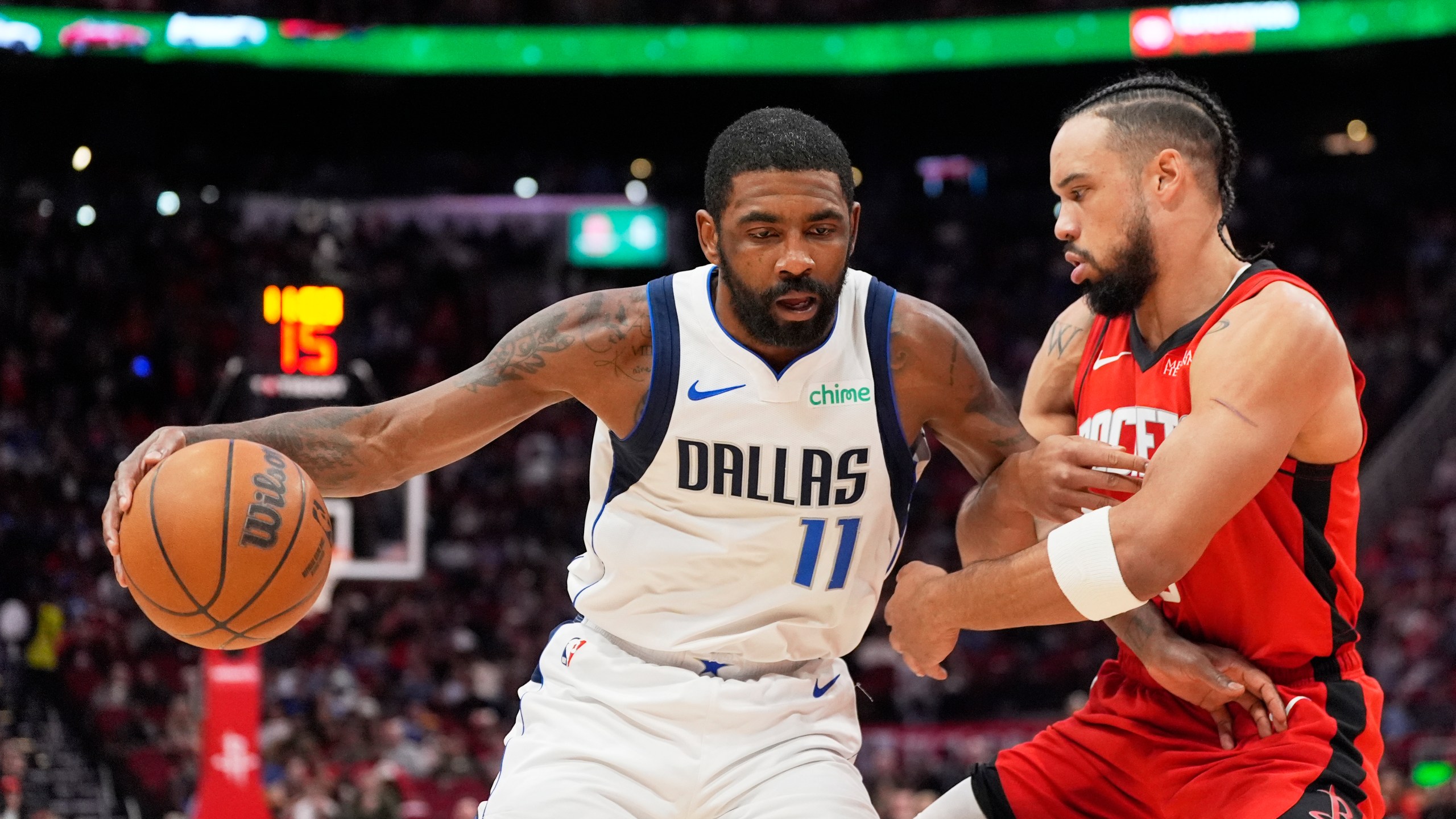 Dallas Mavericks' Kyrie Irving (11) is defended by Houston Rockets' Dillon Brooks during the first half of an NBA basketball game Wednesday, Jan. 1, 2025, in Houston. (AP Photo/David J. Phillip)