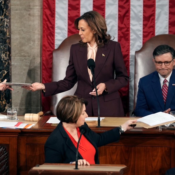 Vice President Kamala Harris is handed a certification as House Speaker Mike Johnson of La., watches while teller Sen. Amy Klobuchar, D-Minn., stands at the clerk's podium as a joint session of Congress convenes to confirm the Electoral College votes, affirming President-elect Donald Trump's victory in the presidential election, Monday, Jan. 6, 2025, at the U.S. Capitol in Washington. (AP Photo/Matt Rourke)