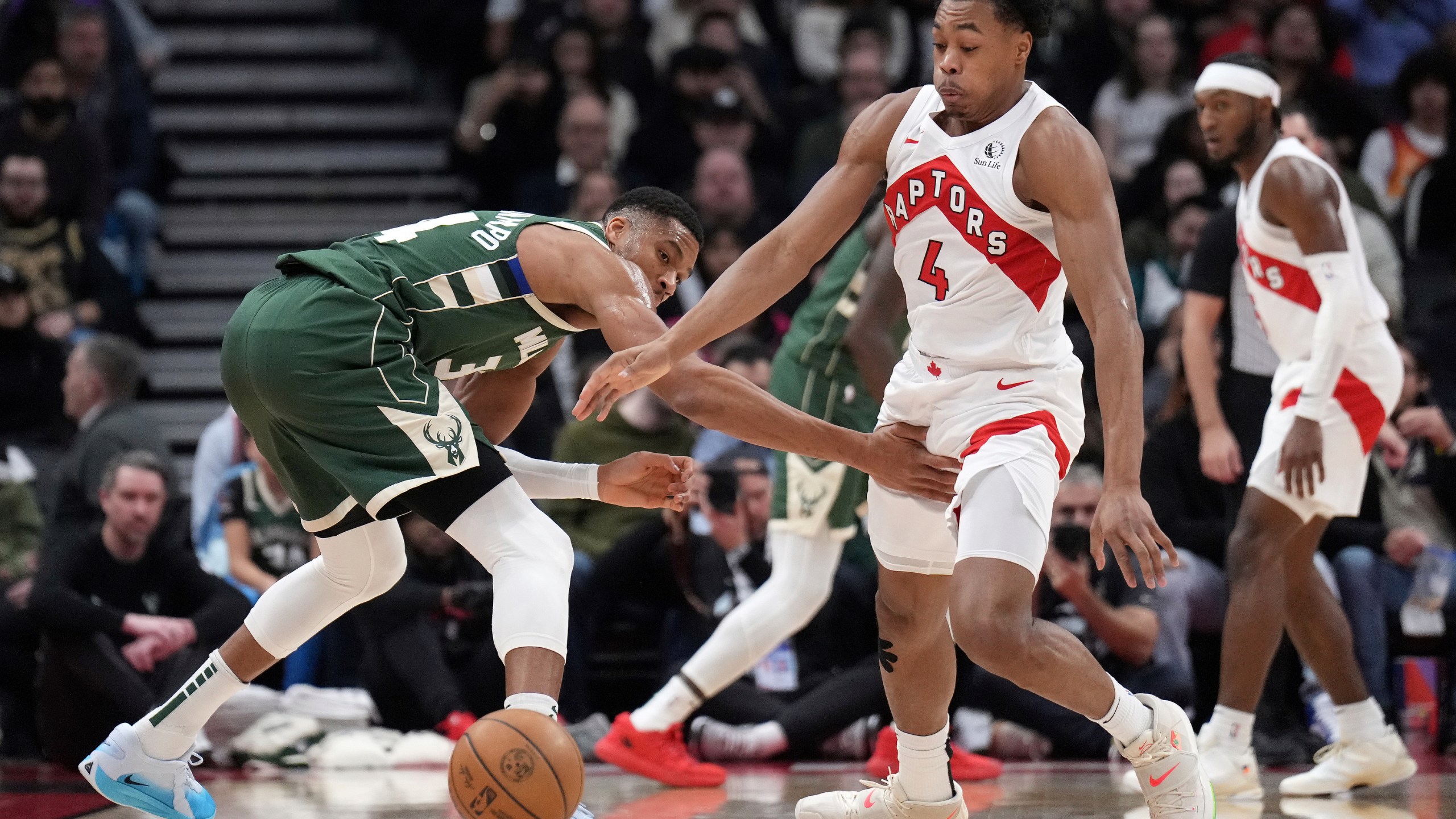 Toronto Raptors forward Scottie Barnes (4) steals the ball from Milwaukee Bucks forward Giannis Antetokounmpo during the first half of an NBA basketball game in Toronto, Monday, Jan. 6, 2025. (Nathan Denette/The Canadian Press via AP)