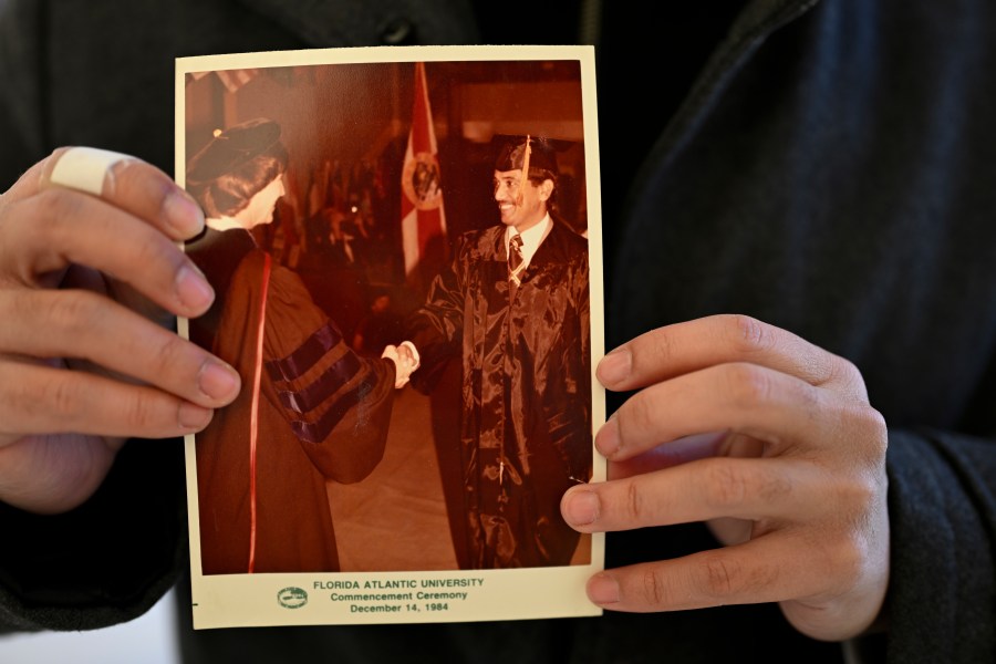 Ibrahim Almadi holds a photo of his father Saad Almadi graduating from college in 1984, in Washington Monday, Dec. 23, 2024. Saad Almadi, a dual U.S.-Saudi citizen was jailed for social media posts critical of the kingdom's crown prince. He was released from a Saudi prison in March 2023 and banned from returning to his home in south Florida. (AP Photo/John McDonnell)