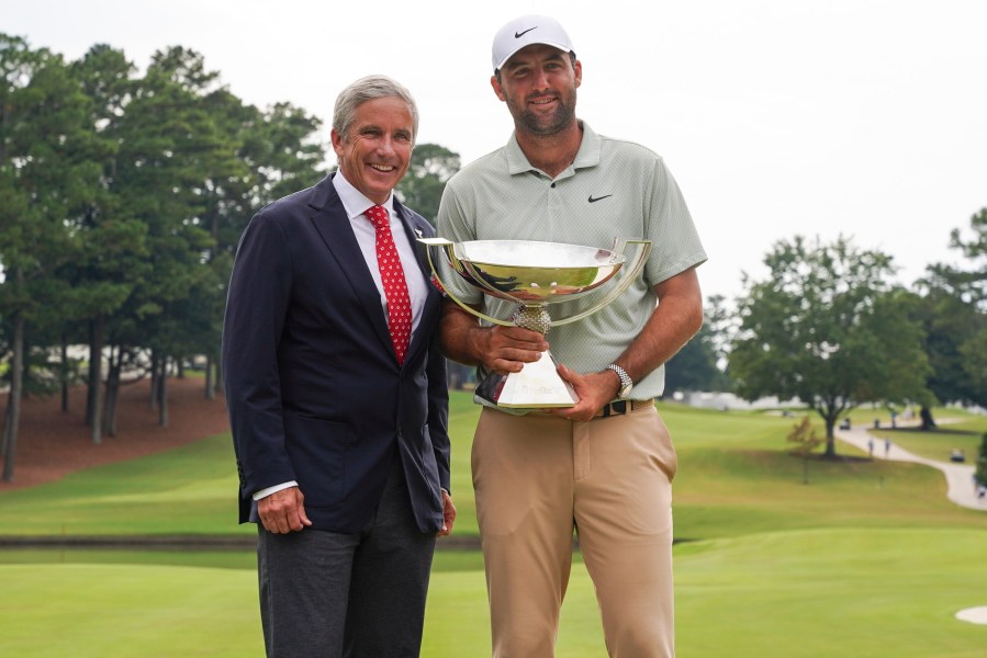 FILE - PGA Tour Commissioner Jay Monahan, left, poses with Scottie Scheffler and the FedExCup Trophy after Scheffler won the final round of the Tour Championship golf tournament, Sunday, Sept. 1, 2024, in Atlanta. (AP Photo/Jason Allen, File)