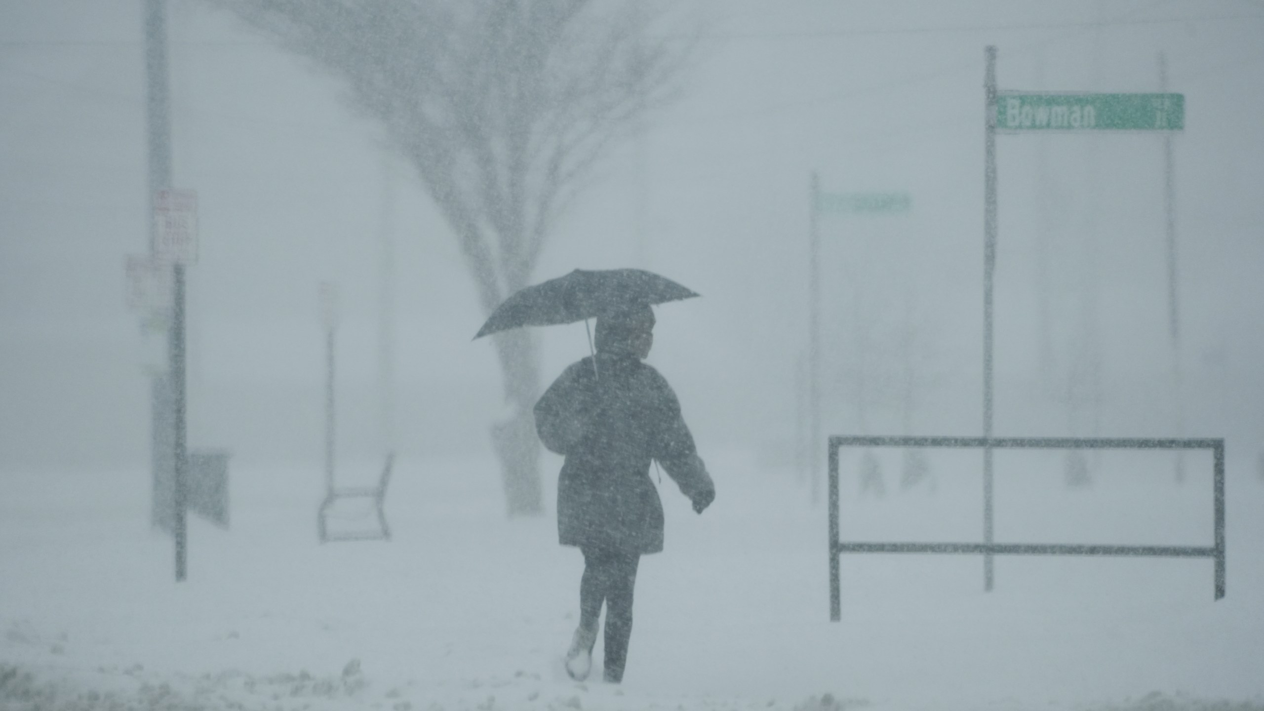 A person holds an umbrella as they walk during a winter storm, Monday, Jan. 6, 2025, in Cincinnati. (AP Photo/Joshua A. Bickel)