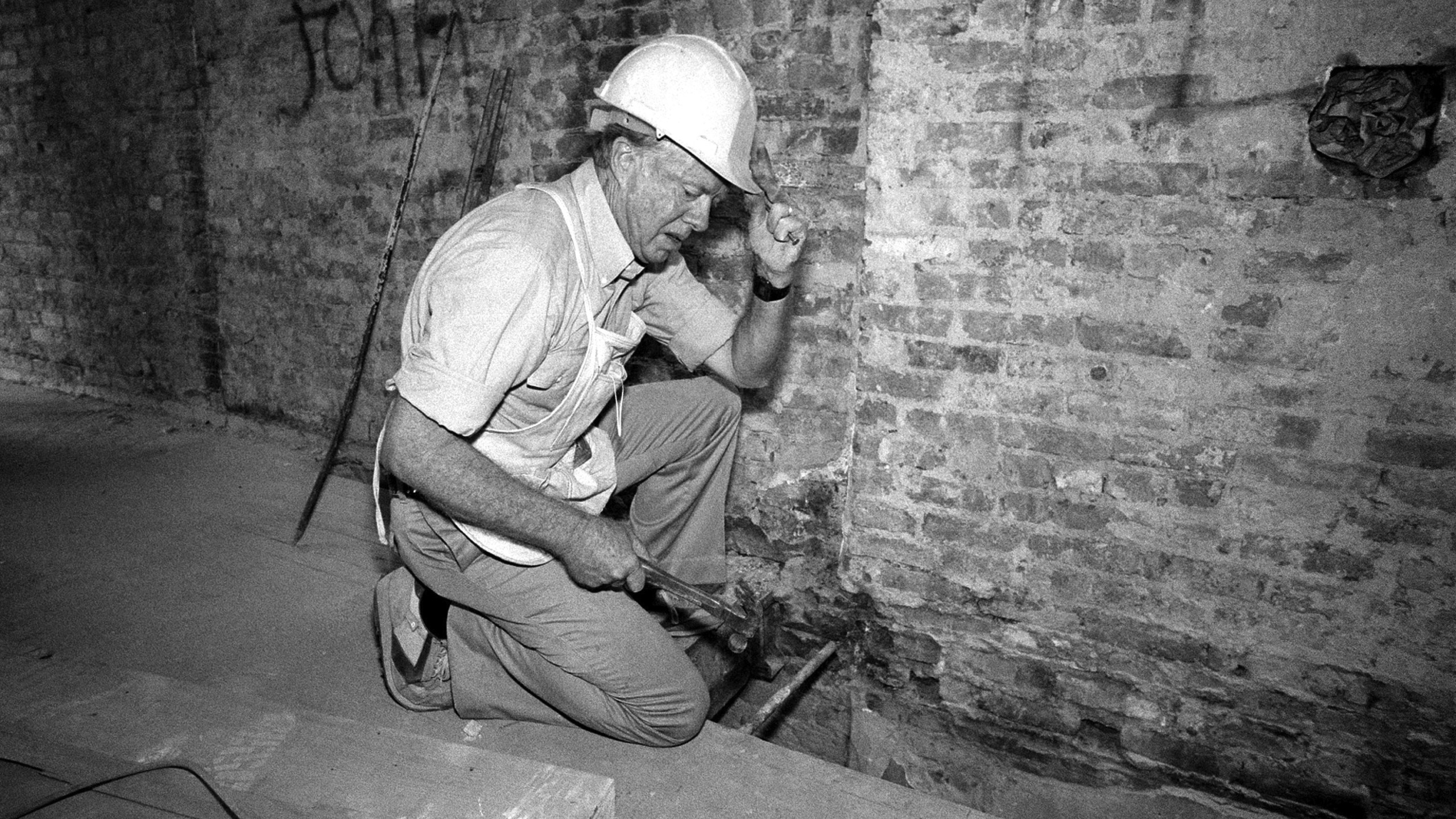 FILE - Former President Jimmy Carter works on a renovation of a tenement building in New York's Lower East Side neighborhood, Sept. 3, 1984. Carter, along with 50 other volunteers from Georgia, are working to build new homes for 19 families as part of the Habitat for Humanity project. (AP Photo/Mario Cabrera, File)