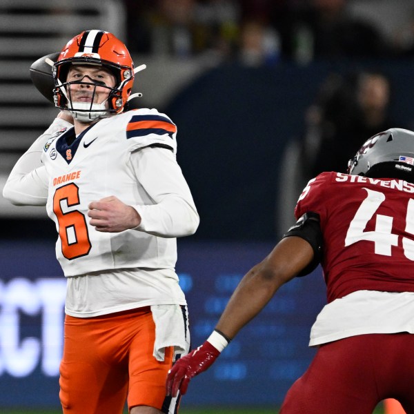 Syracuse quarterback Kyle McCord (6) passes under pressure from Washington State edge Raam Stevenson (45) during the first half of the Holiday Bowl NCAA college football game Friday, Dec. 27, 2024, in San Diego. (AP Photo/Denis Poroy)