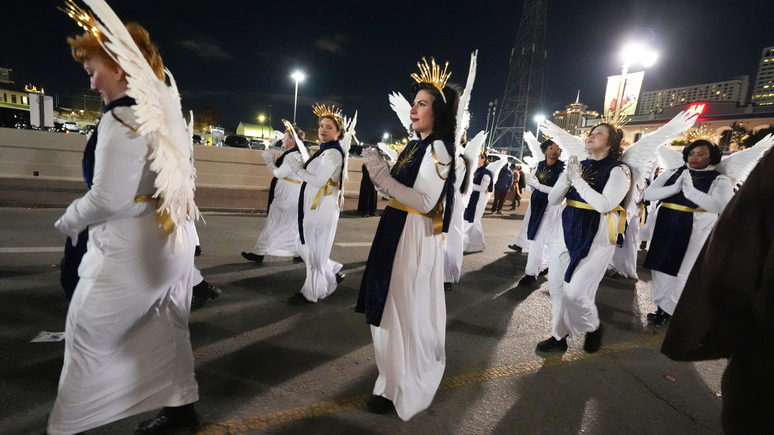 Parade-goers dressed as angels walk during the annual Krewe de Jeanne d'Arc parade, kicking off the Mardi Gras season, in New Orleans, Monday, Jan. 6, 2025. (AP Photo/Gerald Herbert)