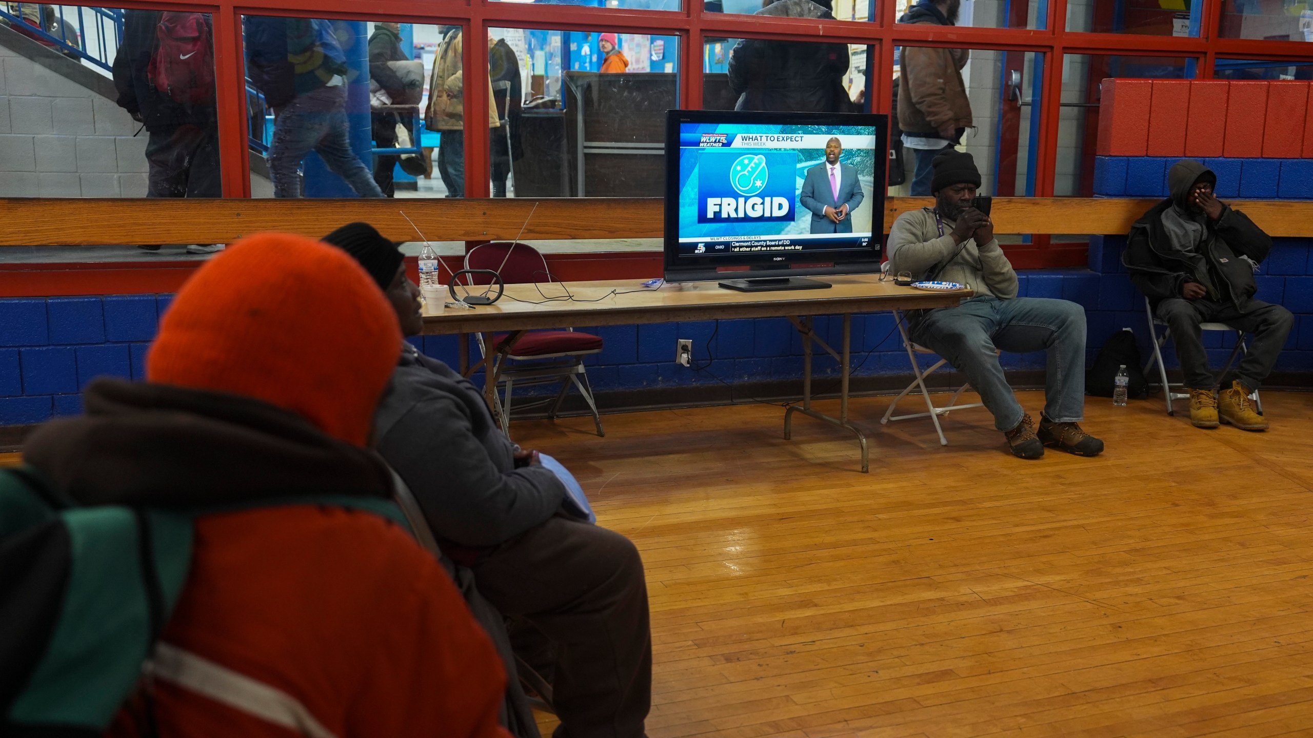 Patrons watch a local weather report while sheltering from the cold inside a recreation center, Monday, Jan. 6, 2025, in Cincinnati. (AP Photo/Joshua A. Bickel)