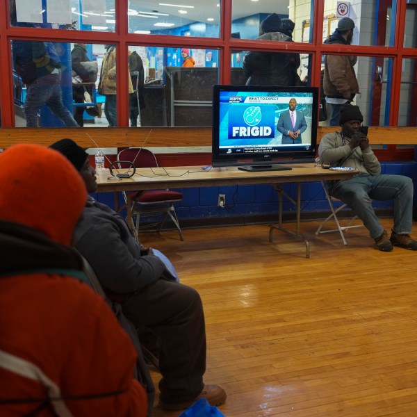 Patrons watch a local weather report while sheltering from the cold inside a recreation center, Monday, Jan. 6, 2025, in Cincinnati. (AP Photo/Joshua A. Bickel)