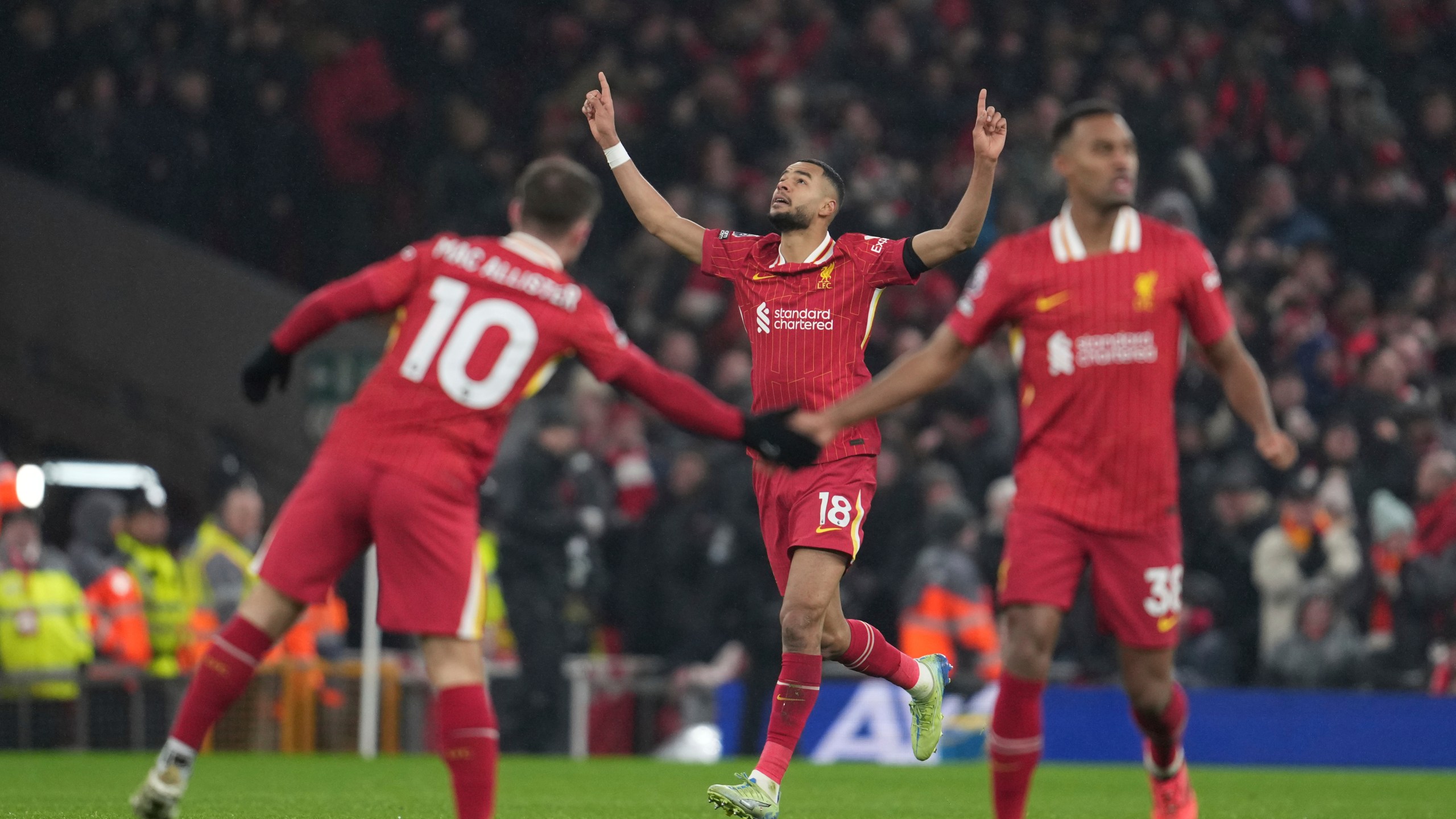 Liverpool's Cody Gakpo, center, celebrates after scoring his side's first goal against Manchester United during the English Premier League soccer match at the Anfield stadium in Liverpool, England, Sunday, Jan. 5, 2025. (AP Photo/Jon Super)