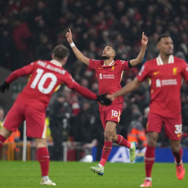 Liverpool's Cody Gakpo, center, celebrates after scoring his side's first goal against Manchester United during the English Premier League soccer match at the Anfield stadium in Liverpool, England, Sunday, Jan. 5, 2025. (AP Photo/Jon Super)