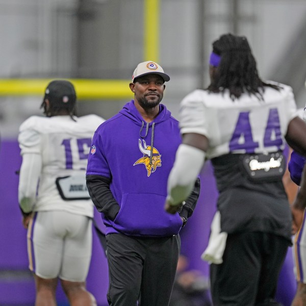 FILE - Minnesota Vikings defensive coordinator Brian Flores, center, stands on the field during an NFL football workout in Eagan, Minn., Wednesday, Oct. 30, 2024. (AP Photo/Abbie Parr, File)