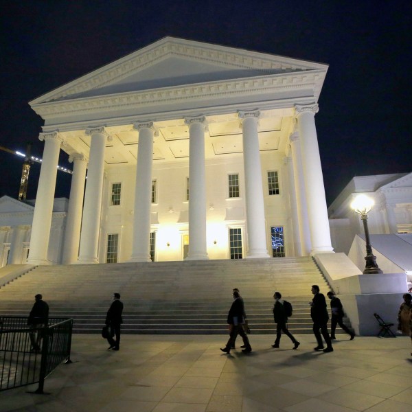 FILE - House of Delegates members walk past the south portico at the Virginia State Capitol in Richmond, Va., Wednesday, April 22, 2020. (Bob Brown/Richmond Times-Dispatch via AP, Pool, File)