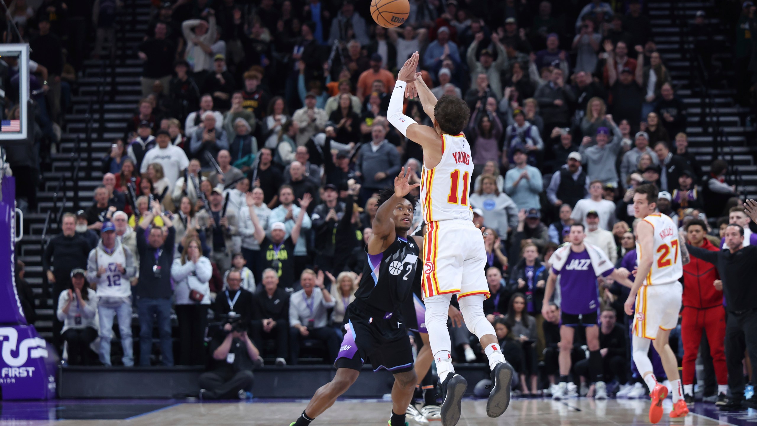 Atlanta Hawks guard Trae Young (11) shoots a three point shot from half court over Utah Jazz guard Collin Sexton (2) at the buzzer to win an NBA basketball game, Tuesday, Jan. 7, 2025, in Salt Lake City. (AP Photo/Rob Gray)