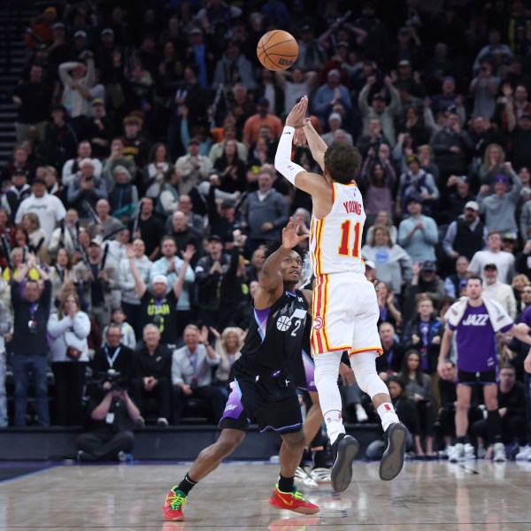 Atlanta Hawks guard Trae Young (11) shoots a three point shot from half court over Utah Jazz guard Collin Sexton (2) at the buzzer to win an NBA basketball game, Tuesday, Jan. 7, 2025, in Salt Lake City. (AP Photo/Rob Gray)