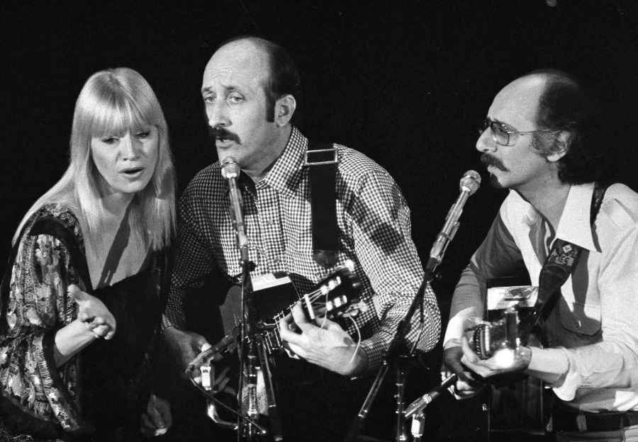 FILE - Folk trio Peter, Paul and Mary, from left, Mary Travers, Paul Stookey and Peter Yarrow, perform at a Los Angeles benefit to aid to Cambodian refugees on Jan. 30, 1980. (AP Photo/George Brich, File)