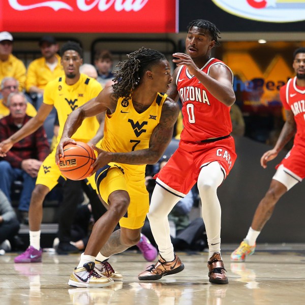 West Virginia guard Javon Small (7) is defended by Arizona guard Jaden Bradley (0) during the second half of an NCAA college basketball game, Tuesday, Jan. 7, 2025, in Morgantown, W.Va. (AP Photo/Kathleen Batten)