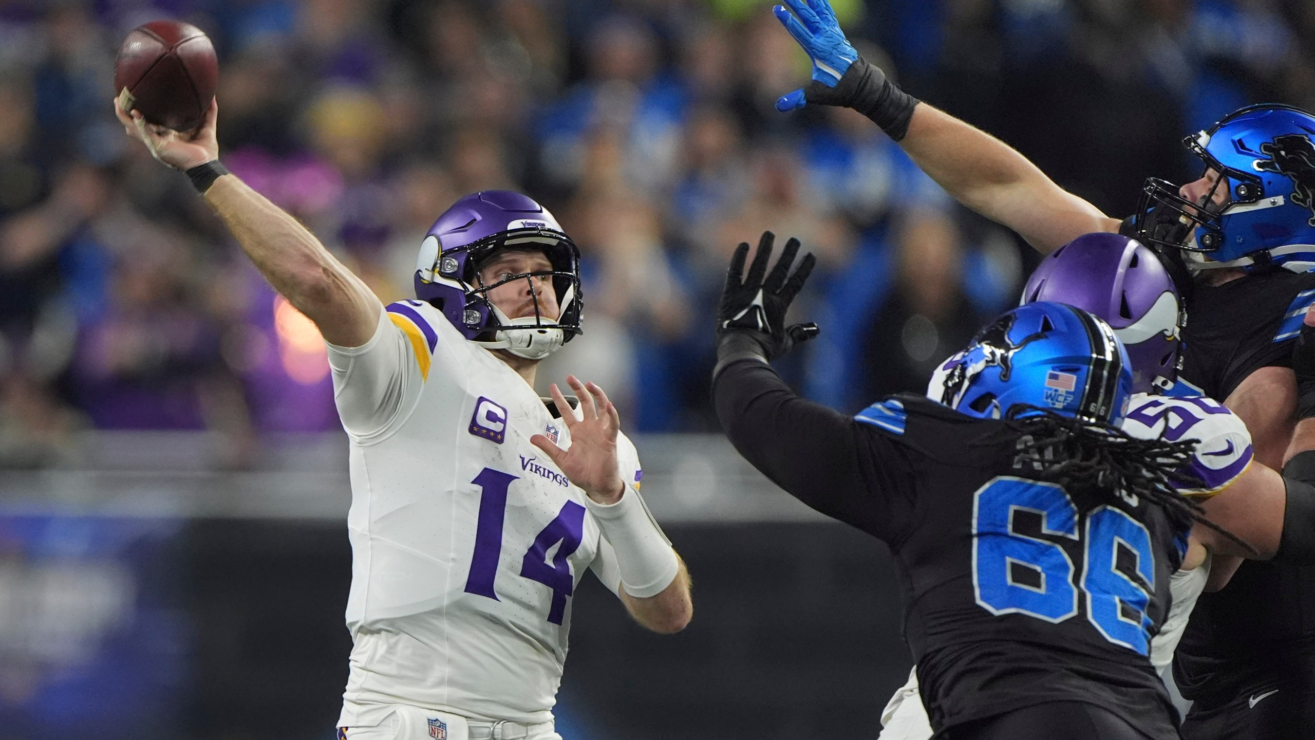 Minnesota Vikings quarterback Sam Darnold (14) throws against the Detroit Lions under pressure during the first half of an NFL football game Sunday, Jan. 5, 2025, in Detroit. (AP Photo/Charlie Riedel)