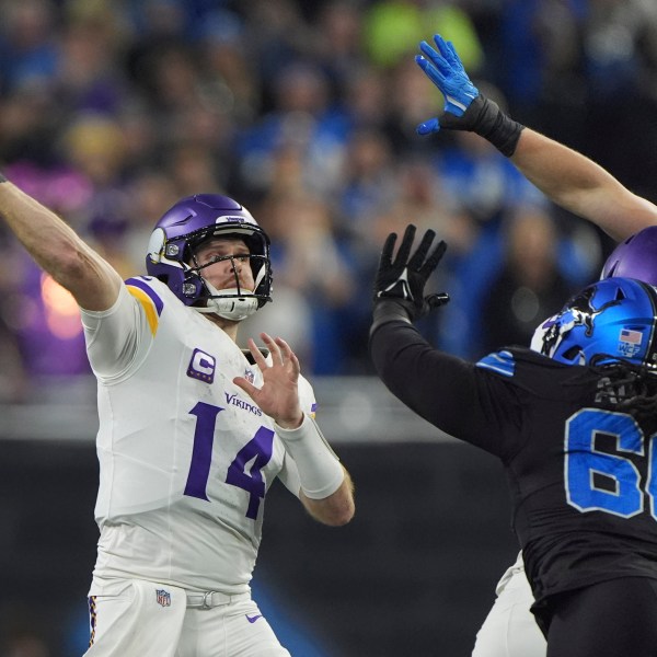 Minnesota Vikings quarterback Sam Darnold (14) throws against the Detroit Lions under pressure during the first half of an NFL football game Sunday, Jan. 5, 2025, in Detroit. (AP Photo/Charlie Riedel)