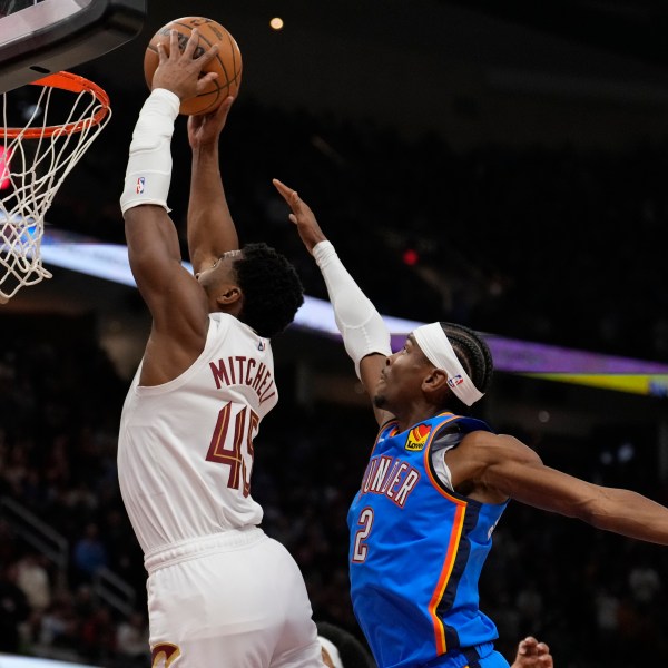 Cleveland Cavaliers guard Donovan Mitchell (45) goes up for a dunk in front of Oklahoma City Thunder guard Shai Gilgeous-Alexander (2) in the first half of an NBA basketball game, Wednesday, Jan. 8, 2025, in Cleveland. (AP Photo/Sue Ogrocki)