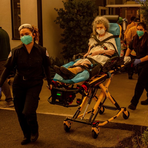 A resident is evacuated from a senior living facility as the Eaton Fire approaches Wednesday, Jan. 8, 2025, in Altadena, Calif. (AP Photo/Ethan Swope)