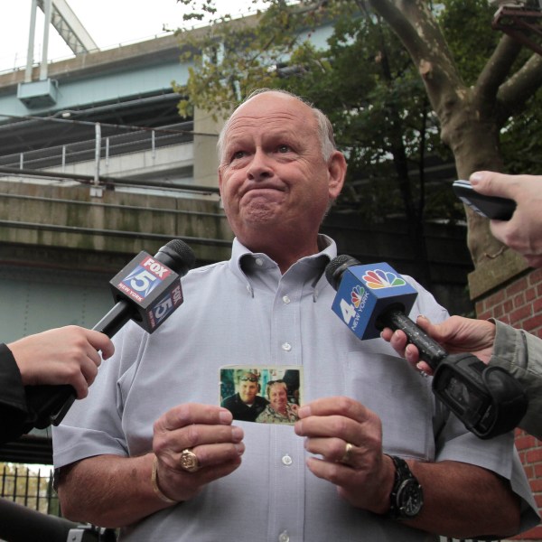 FILE - Ken Fairben holds a photo showing his son Keith, left, a victim of the Sept, 11, attacks, as he talks with reporters Oct. 15, 2012, outside Fort Hamilton Army base in Brooklyn, N.Y. (AP Photo/Bebeto Matthews, File)