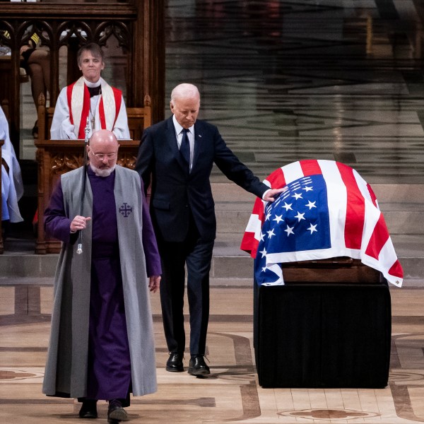 President Joe Biden touches the casket of former President Jimmy Carter after delivering remarks during Carter's state funeral at the National Cathedral, Thursday, Jan. 9, 2025, in Washington. (Haiyun Jiang/The New York Times via AP, Pool)