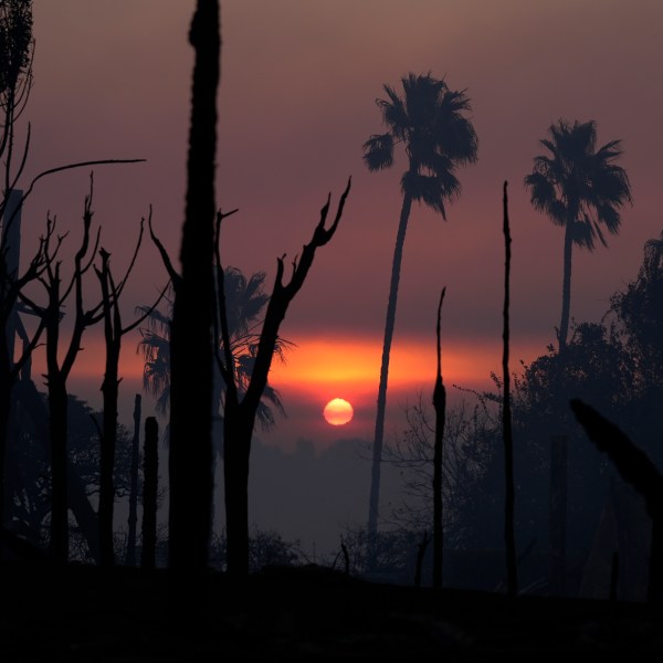 The sun rises as the Palisades Fire ravagee a neighborhood amid high winds in the Pacific Palisades neighborhood of Los Angeles, Thursday, Jan. 9, 2025. (AP Photo/Damian Dovarganes)