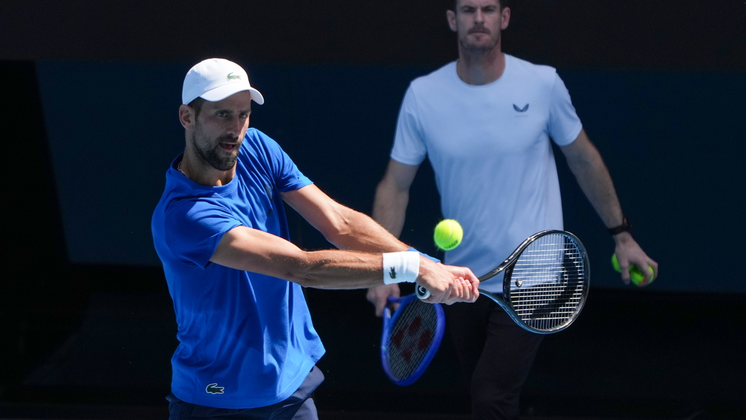 Serbia's Novak Djokovic is watched by his coach Andy Murray, right, during a practice session ahead of the Australian Open tennis championship in Melbourne, Australia, Thursday, Jan. 9, 2025. (AP Photo/Mark Baker)