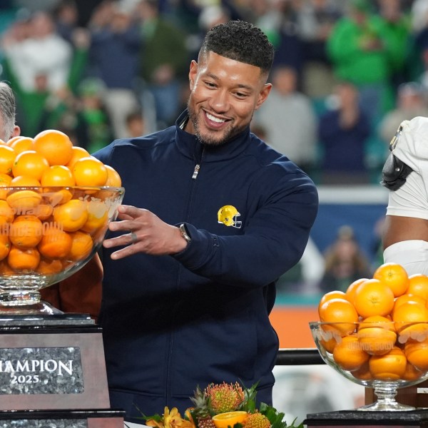 Notre Dame head coach Marcus Freeman touches the Orange Bowl trophy at the end of the Orange Bowl College Football Playoff semifinal game against Penn State, Thursday, Jan. 9, 2025, in Miami Gardens, Fla. (AP Photo/Lynne Sladky)