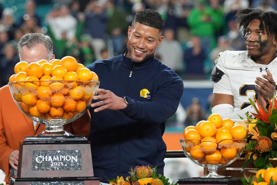 Notre Dame head coach Marcus Freeman touches the Orange Bowl trophy at the end of the Orange Bowl College Football Playoff semifinal game against Penn State, Thursday, Jan. 9, 2025, in Miami Gardens, Fla. (AP Photo/Lynne Sladky)