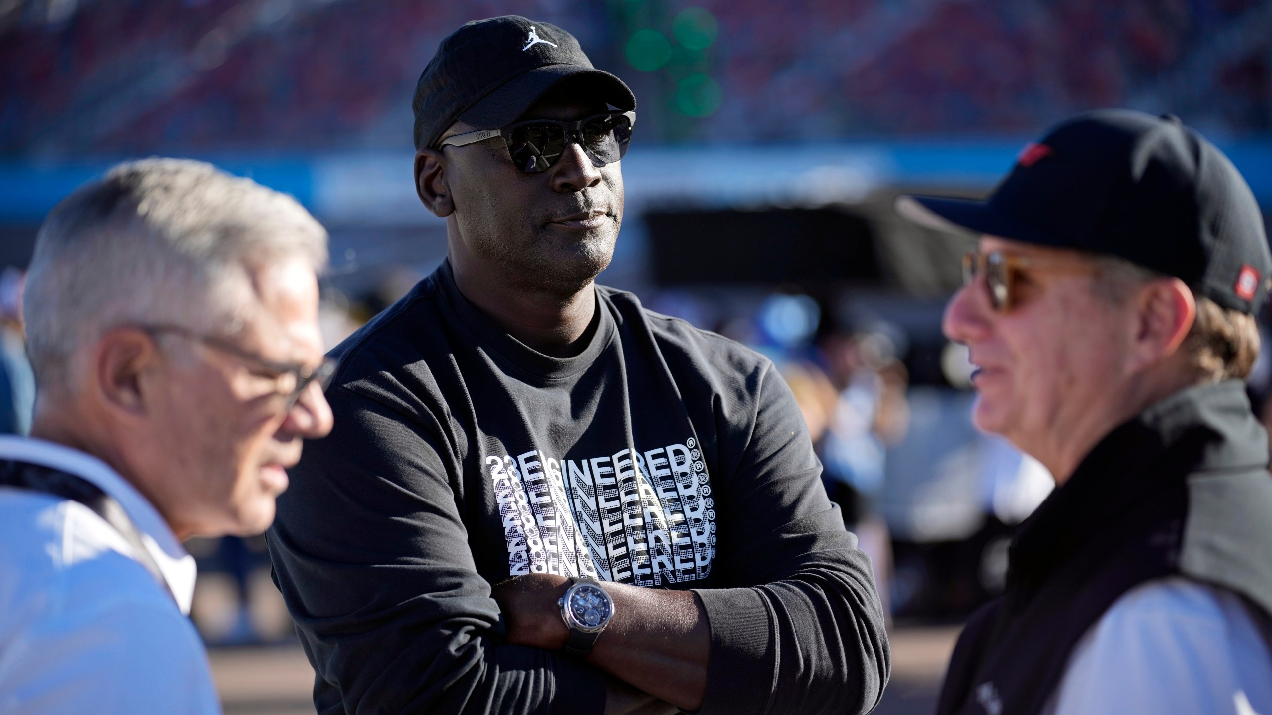 FILE - Michael Jordan, center, and Curtis Polk, left, co-owners of 23XI Racing, watch during qualifying beside 23XI Racing President Steve Lauletta, right, for a NASCAR Cup Series Championship auto race, Saturday, Nov. 9, 2024, in Avondale, Ariz. (AP Photo/John Locher, File)