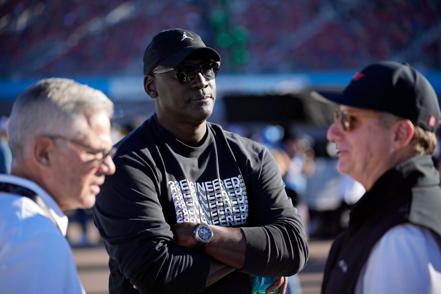 FILE - Michael Jordan, center, and Curtis Polk, left, co-owners of 23XI Racing, watch during qualifying beside 23XI Racing President Steve Lauletta, right, for a NASCAR Cup Series Championship auto race, Saturday, Nov. 9, 2024, in Avondale, Ariz. (AP Photo/John Locher, File)