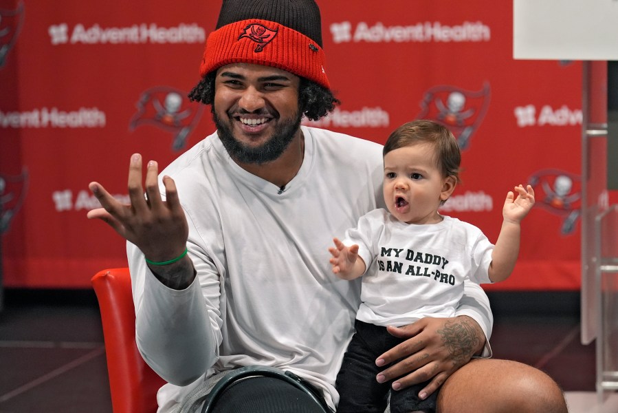 Tampa Bay Buccaneers offensive lineman Tristan Wirfs smiles as he holds his son Julius during an NFL football news conference Thursday, Jan. 9, 2025, in Tampa, Fla. Wirfs has been named to the AP All-Pro football team. (AP Photo/Chris O'Meara)