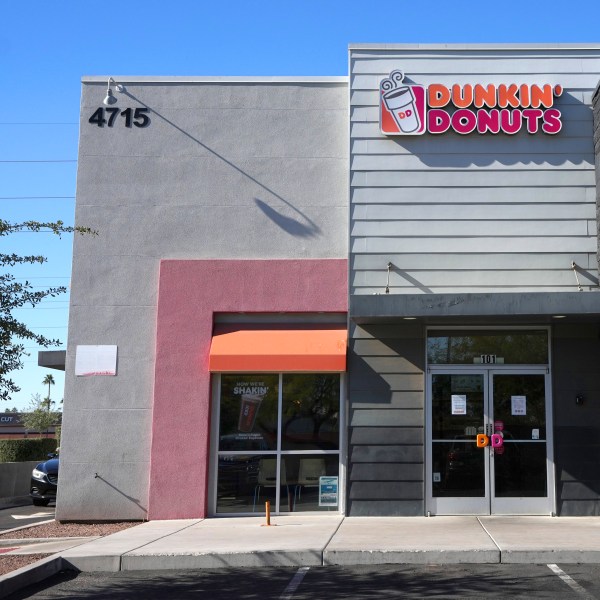 Signs on the doors of a Dunkin' Donuts restaurant explains that customers will find limited doughnut selections for sale Friday, Jan. 10, 2025, in Tempe, Ariz. (AP Photo/Ross D. Franklin)