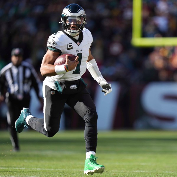 Philadelphia Eagles quarterback Jalen Hurts (1) running with the ball during the first half of an NFL football game against the Washington Commanders, Sunday, Dec. 22, 2024, in Landover, Md. (AP Photo/Stephanie Scarbrough)