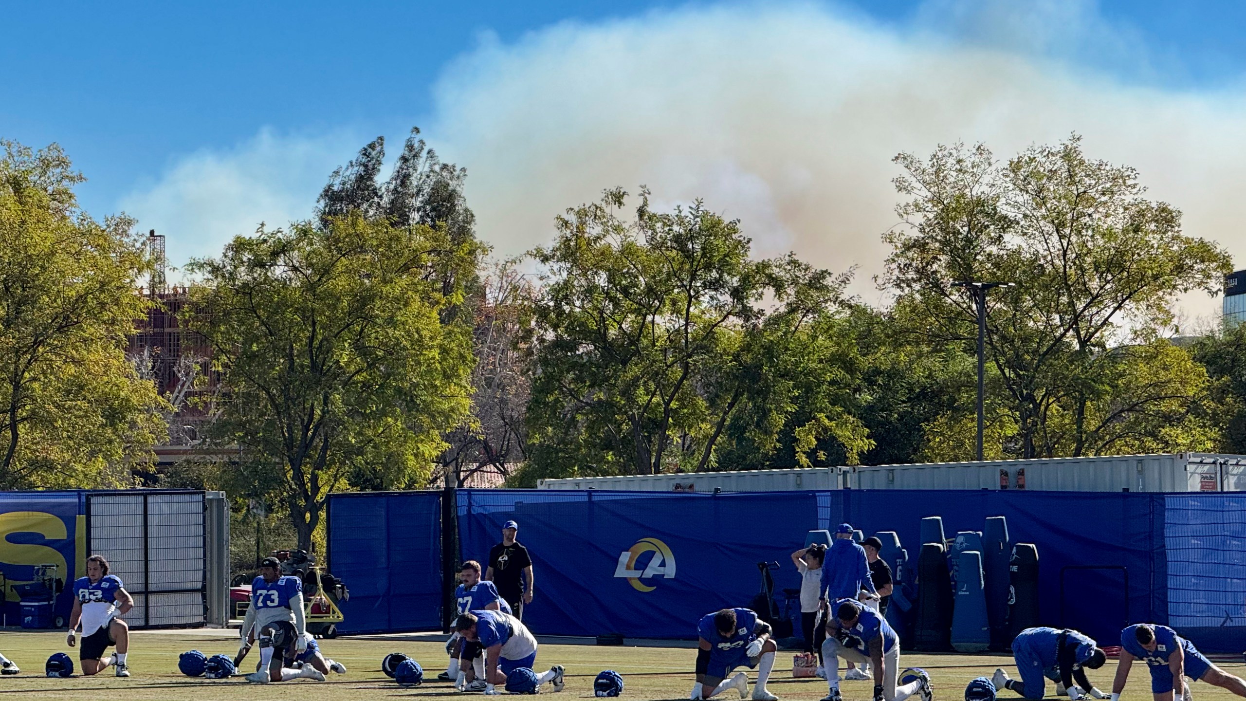 The Los Angeles Rams NFL football team practices under a plume of smoke from the Palisades Fire in preparation for a playoff game against the Minnesota Vikings in the Woodland Hills section of Los Angeles, Friday, Jan. 10, 2025. (AP Photo/Dan Greenspan)