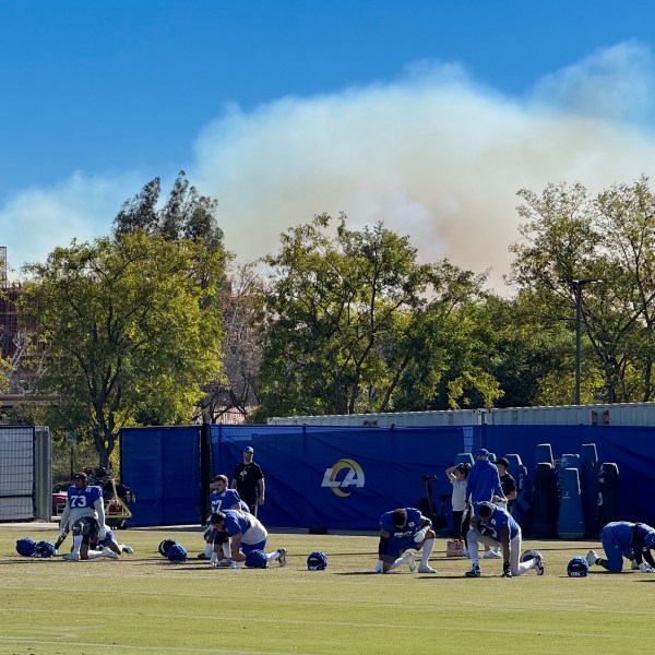 The Los Angeles Rams NFL football team practices under a plume of smoke from the Palisades Fire in preparation for a playoff game against the Minnesota Vikings in the Woodland Hills section of Los Angeles, Friday, Jan. 10, 2025. (AP Photo/Dan Greenspan)