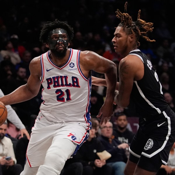 Philadelphia 76ers' Joel Embiid (21) drives past Brooklyn Nets' Jalen Wilson (22) during the second half of an NBA basketball game Saturday, Jan. 4, 2025, in New York. (AP Photo/Frank Franklin II)