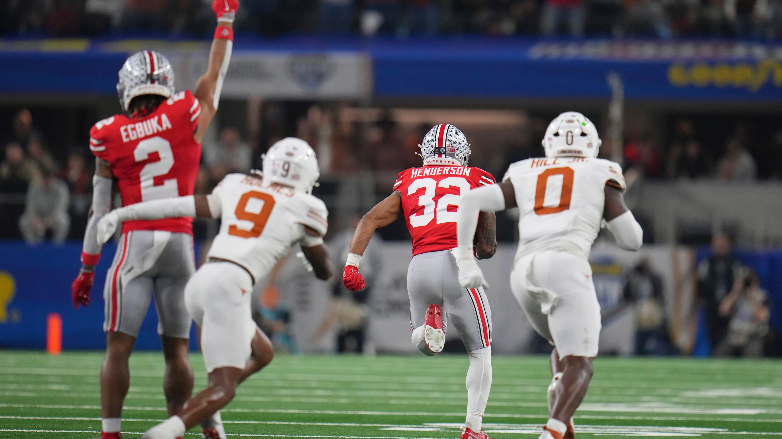 Ohio State wide receiver Emeka Egbuka (2) reacts as running back TreVeyon Henderson (32) runs past Texas defensive back Gavin Holmes (9) and linebacker Anthony Hill Jr. (0) to score during the first half of the Cotton Bowl College Football Playoff semifinal game, Friday, Jan. 10, 2025, in Arlington, Texas. (AP Photo/Julio Cortez)