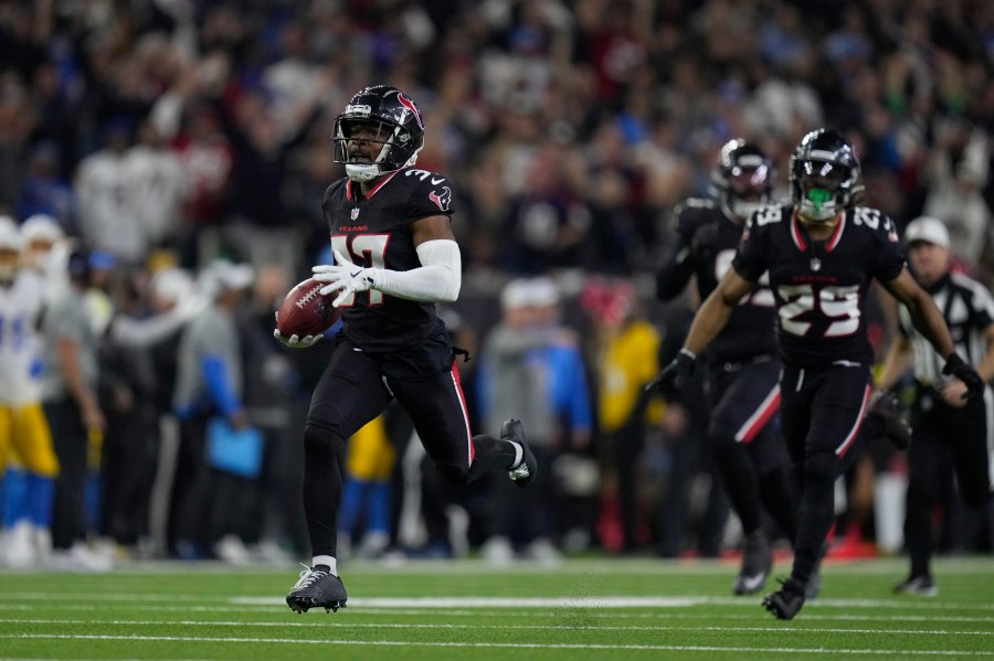 Houston Texans' D'Angelo Ross (37) returns a blocked extra-point attempt by Los Angeles Chargers place kicker Cameron Dicker (11) for two-points during the second half of an NFL wild-card playoff football game Saturday, Jan. 11, 2025, in Houston. (AP Photo/Eric Christian Smith)