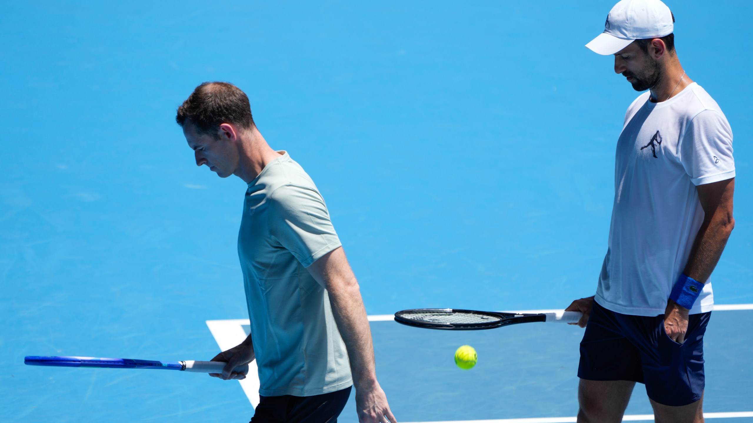 Serbia's Novak Djokovic walks with his coach Andy Murray, left, during a practice session ahead of the Australian Open tennis championship in Melbourne, Australia, Saturday, Jan. 11, 2025. (AP Photo/Ng Han Guan)