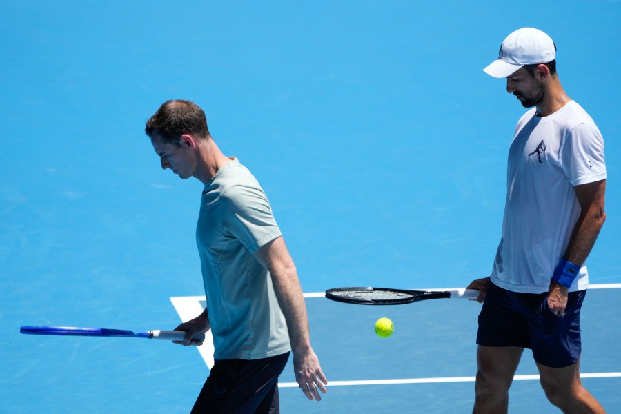 Serbia's Novak Djokovic walks with his coach Andy Murray, left, during a practice session ahead of the Australian Open tennis championship in Melbourne, Australia, Saturday, Jan. 11, 2025. (AP Photo/Ng Han Guan)