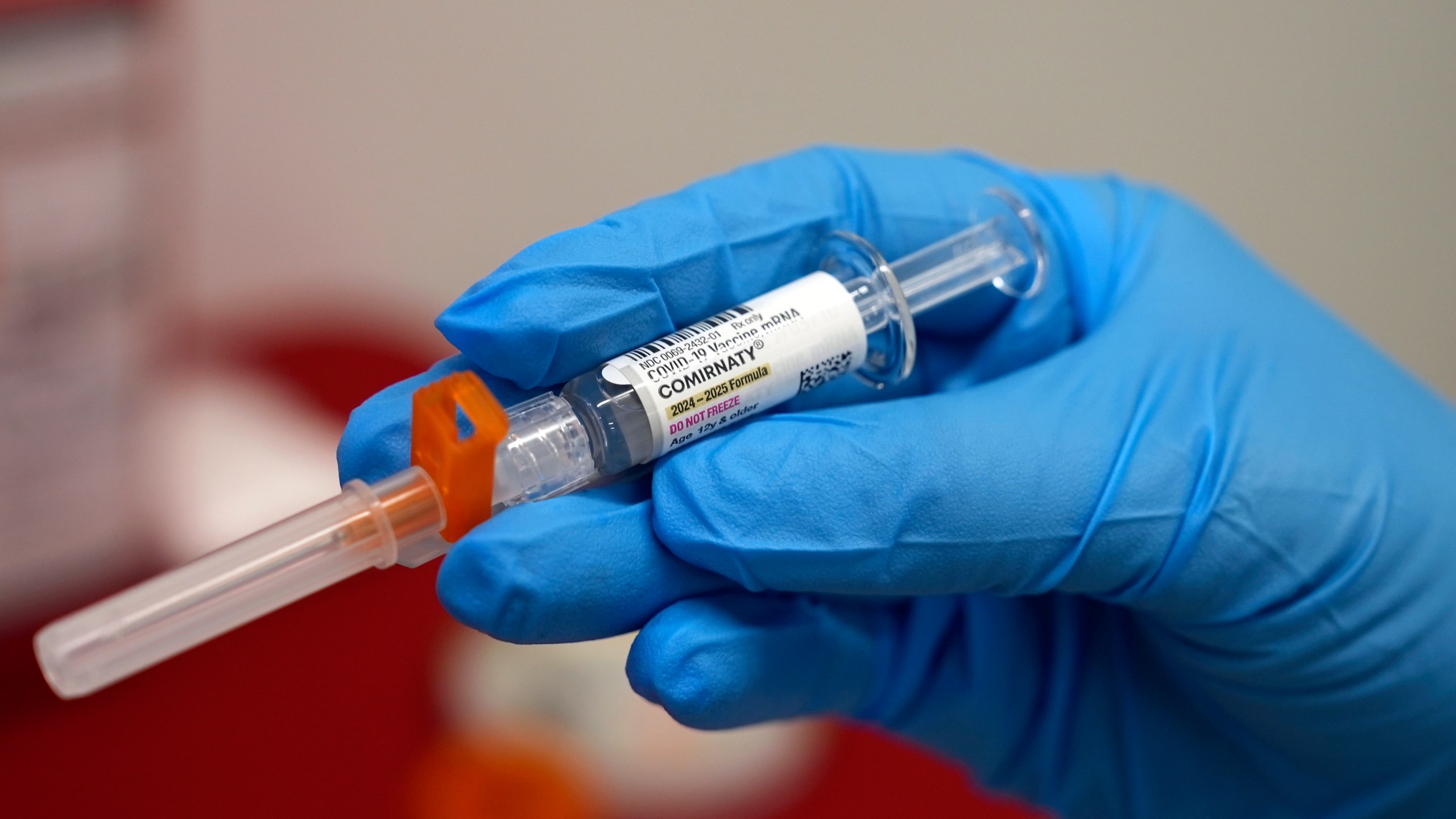 FILE - A pharmacist holds a COVID-19 vaccine at a pharmacy in New York, on Sept. 24, 2024. (AP Photo/Mary Conlon, File)