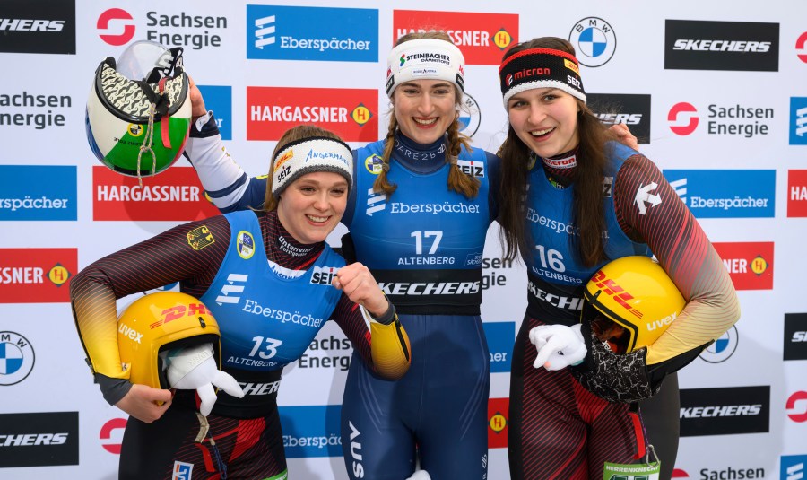 Winner Madeleine Egle from Austria, center, second placed Anna Berreiter, left, and third placed Merle Frobel, both from Germany, celebrate after the women's single-seater 2nd run at the Luge World Cup in Altenberg, Germany, Sunday Jan. 12, 2025. (Robert Michael/dpa via AP)