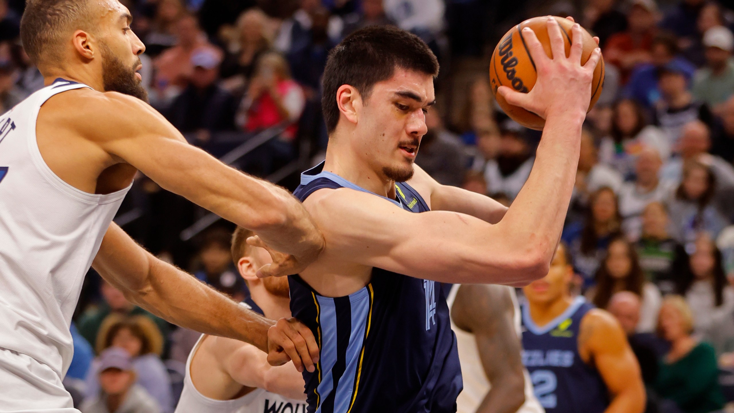 Memphis Grizzlies center Zach Edey, right, grabs a rebound as Minnesota Timberwolves center Rudy Gobert defends him in the first quarter of an NBA basketball game Saturday, Jan. 11, 2025, in Minneapolis. (AP Photo/Bruce Kluckhohn)