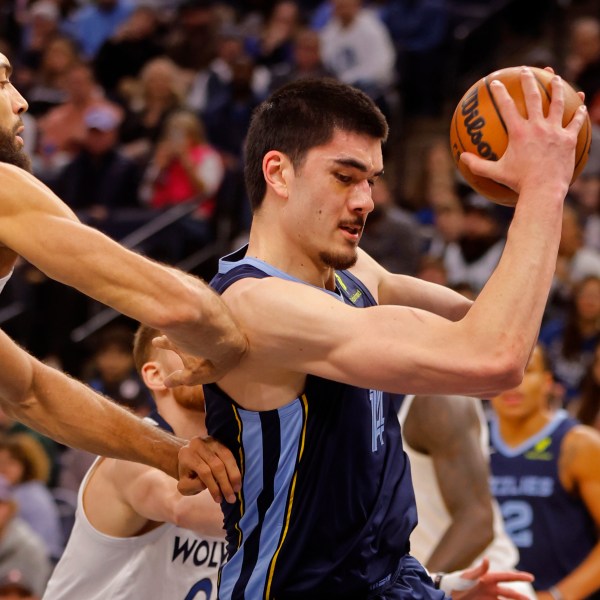 Memphis Grizzlies center Zach Edey, right, grabs a rebound as Minnesota Timberwolves center Rudy Gobert defends him in the first quarter of an NBA basketball game Saturday, Jan. 11, 2025, in Minneapolis. (AP Photo/Bruce Kluckhohn)