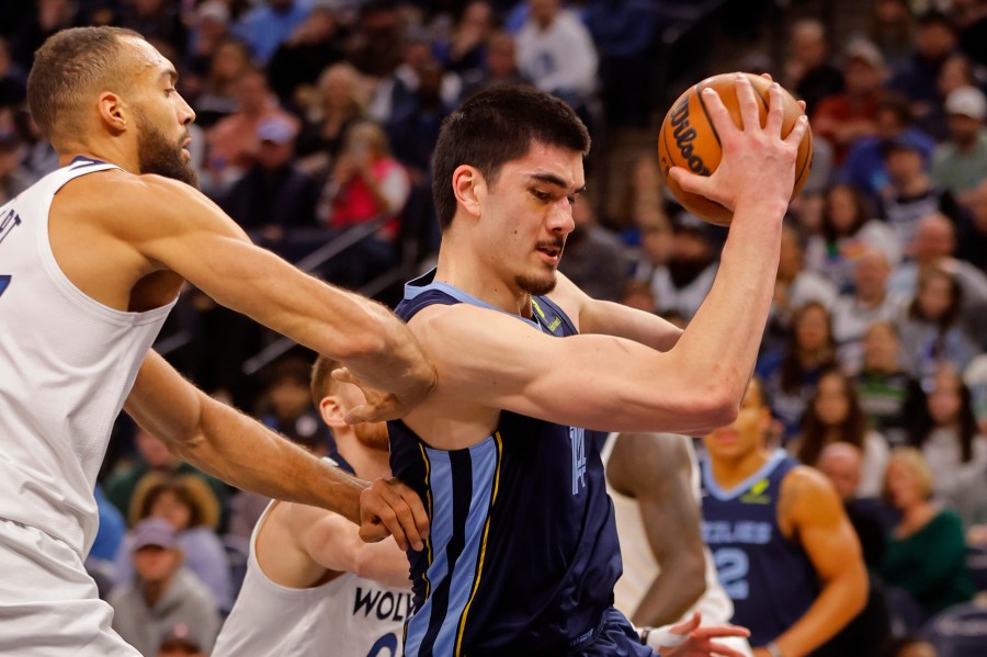 Memphis Grizzlies center Zach Edey, right, grabs a rebound as Minnesota Timberwolves center Rudy Gobert defends him in the first quarter of an NBA basketball game Saturday, Jan. 11, 2025, in Minneapolis. (AP Photo/Bruce Kluckhohn)